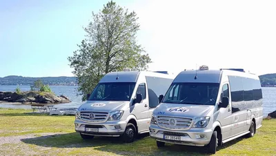 To minibusser fra Grenland Taxi parkert ved sjøen