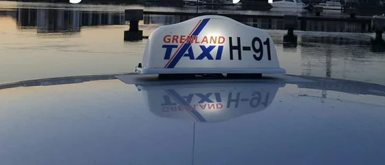 Taklys med Grenland Taxi-logo og bilnummer H-91, speilet i taket på en taxi