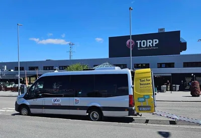 Minibuss fra Grenland Taxi med rullestolrampe utenfor Sandefjord Lufthavn Torp